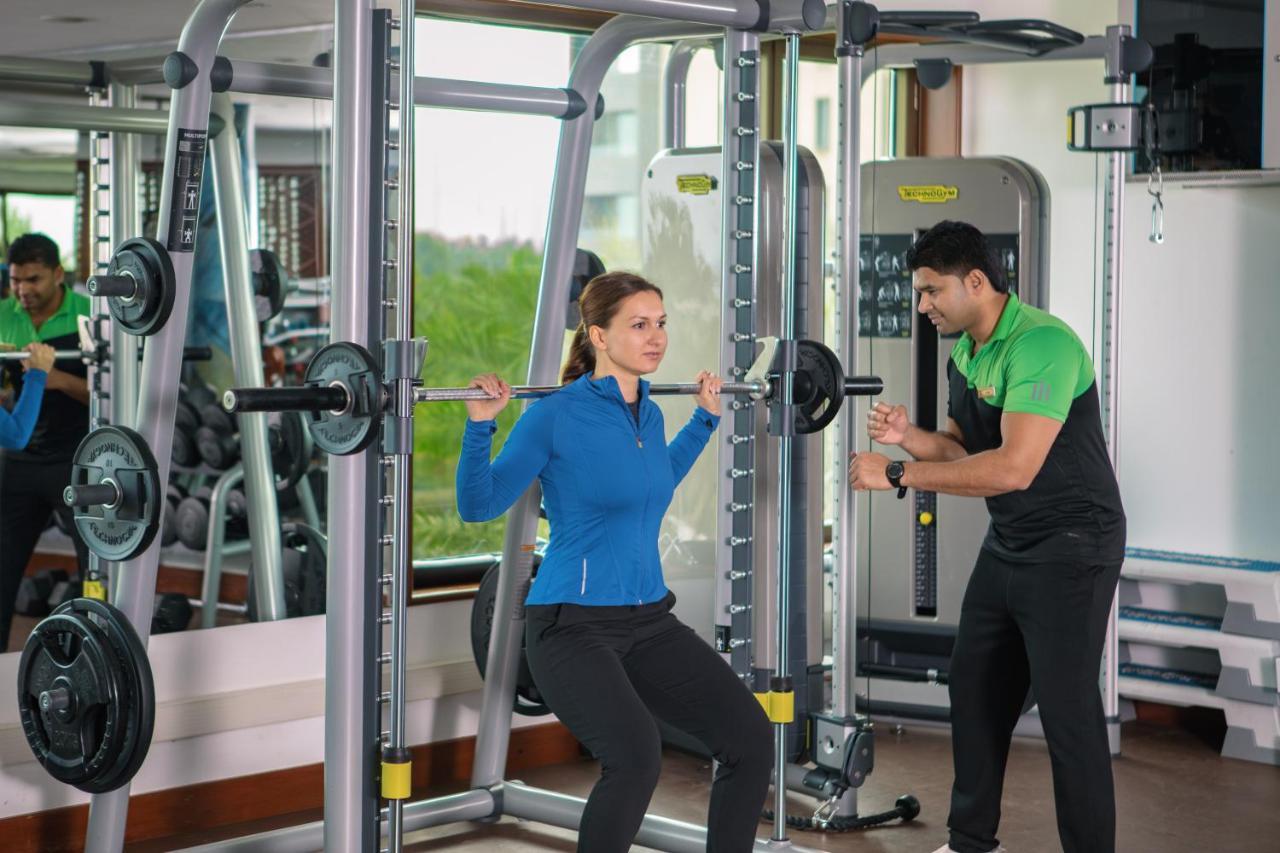 Jumeirah Messilah Beach Kuwait Kuwait City Exterior foto A personal trainer assisting a woman with a squat