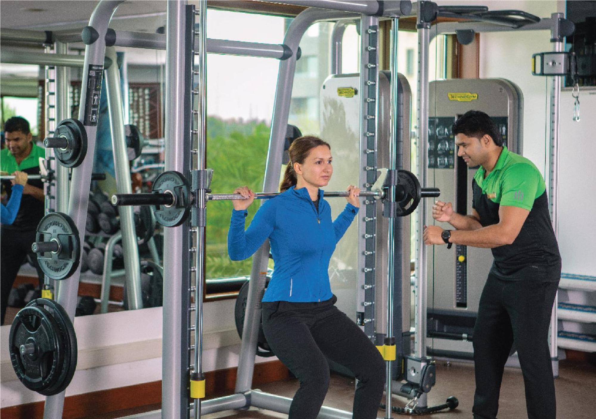 Jumeirah Messilah Beach Kuwait Kuwait City Exterior foto A personal trainer assisting a woman with a weight training exercise